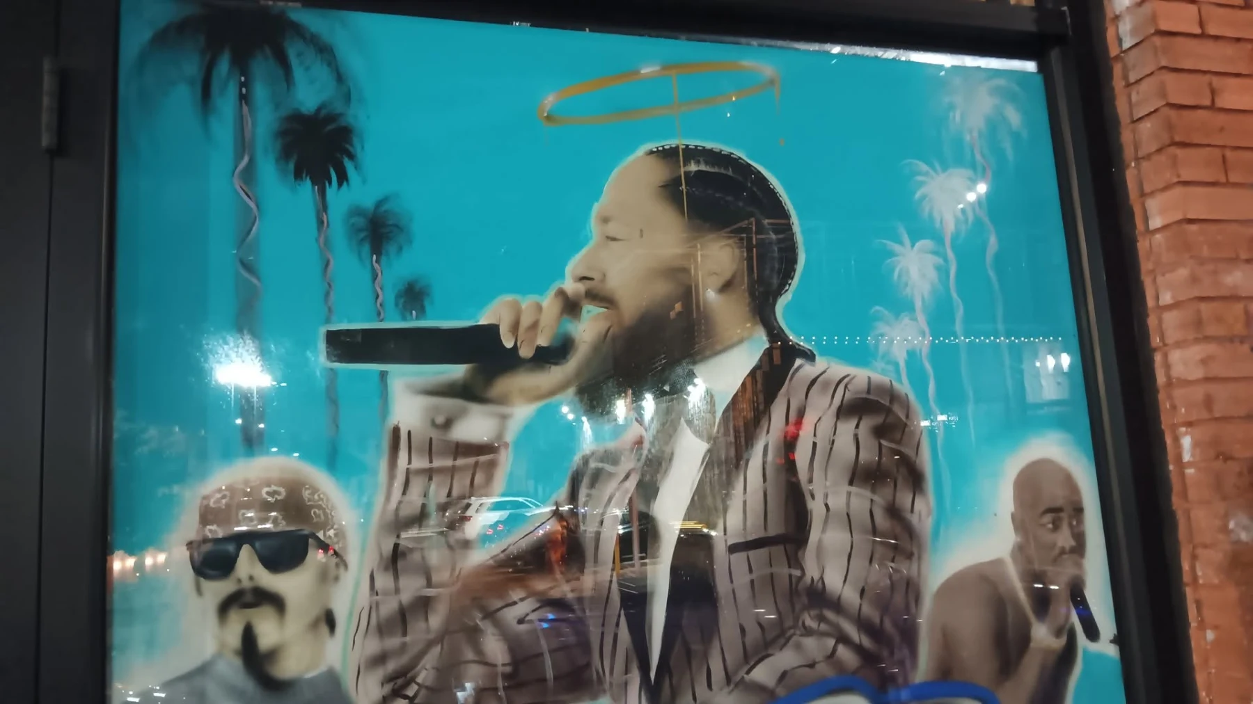 Large singer portrait artwork displayed on a venue window