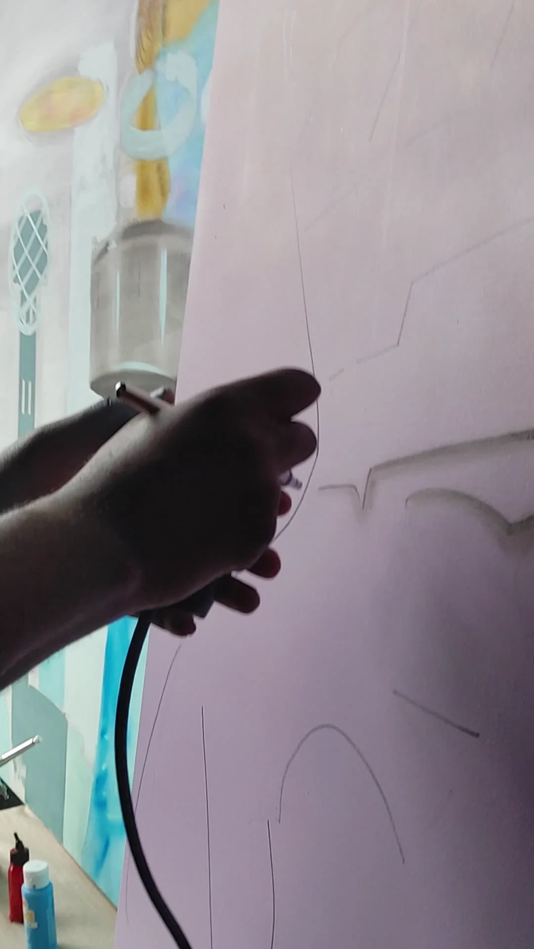 Jonathan airbrushing and sketching a large mural