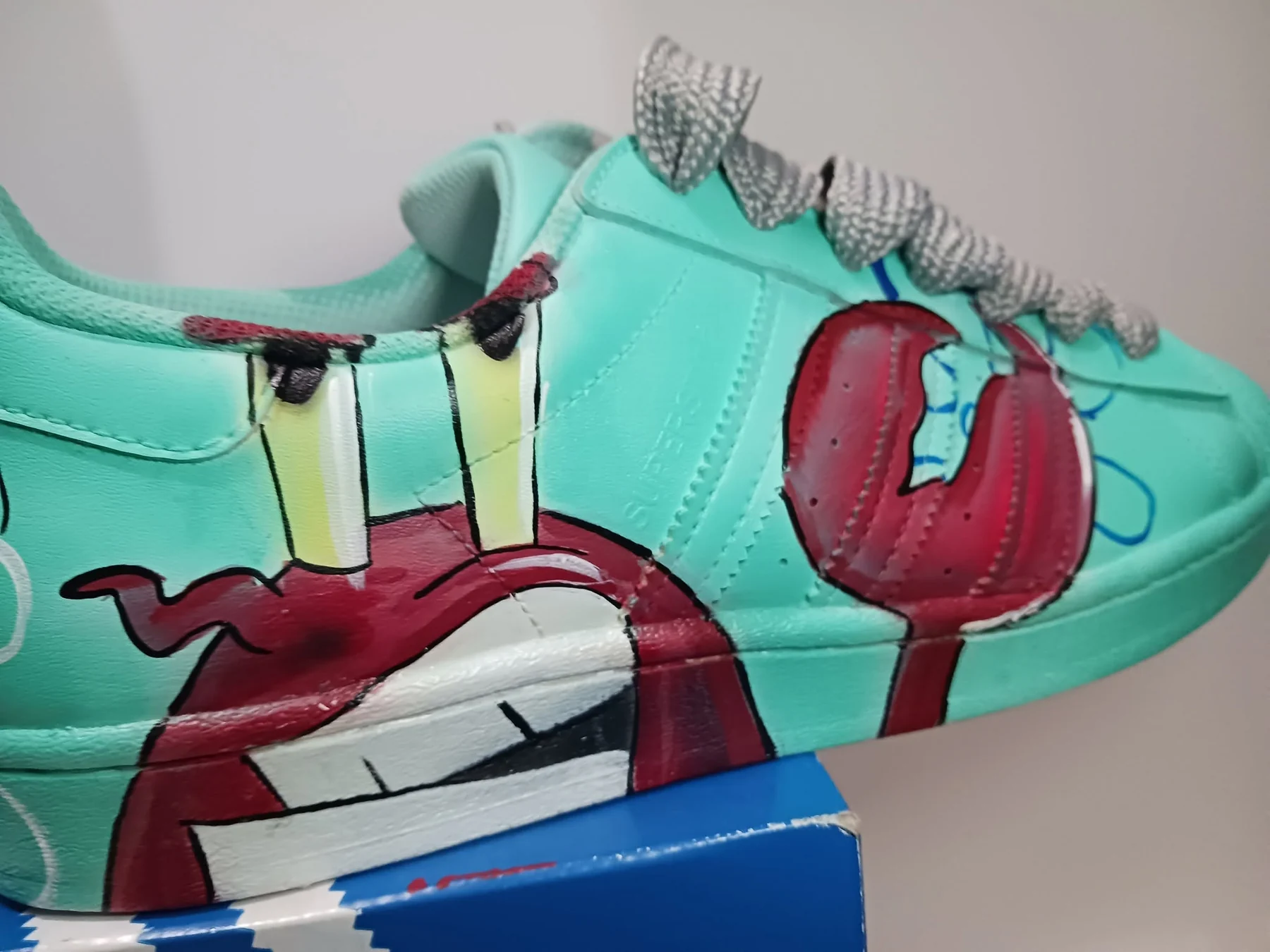 Mint custom sneaker with hand-painted character artwork